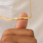 Brillo intenso y actitud serpentina. La Cadena Serpiente de 4 mm y 65 cm es una joya que no pasa desapercibida. Su diseño plano y ondulante refleja la luz con un efecto espejo que envuelve tu cuello con fuerza y distinción. El grosor de 4 mm le da carácter, mientras que su acabado en oro laminado de 18k asegura un estilo duradero, resistente y lleno de presencia. Ideal para usar sola como pieza protagonista o para llevar con dijes minimalistas. 🐍 Una cadena para mujeres y hombres que pisan fuerte y brillan sin miedo.